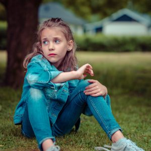 girl sitting on ground sad