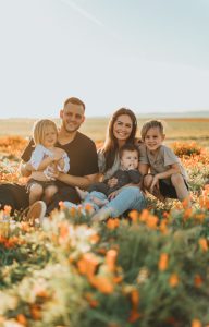 Family sitting in garden of flowers.